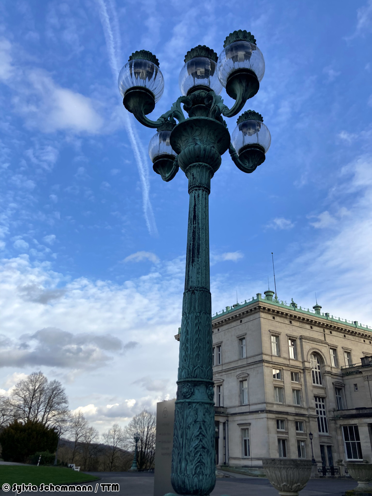 Historische Laterne vor blauem Himmel und der Villa Hügel im Hintergrund