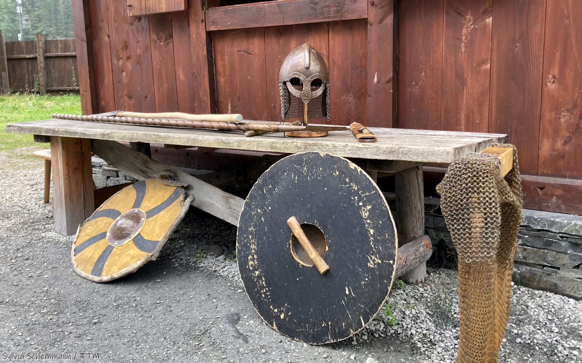 Ein Wikingerhelm auf einem Tisch, davor Schilde
Wikinger Norwegen