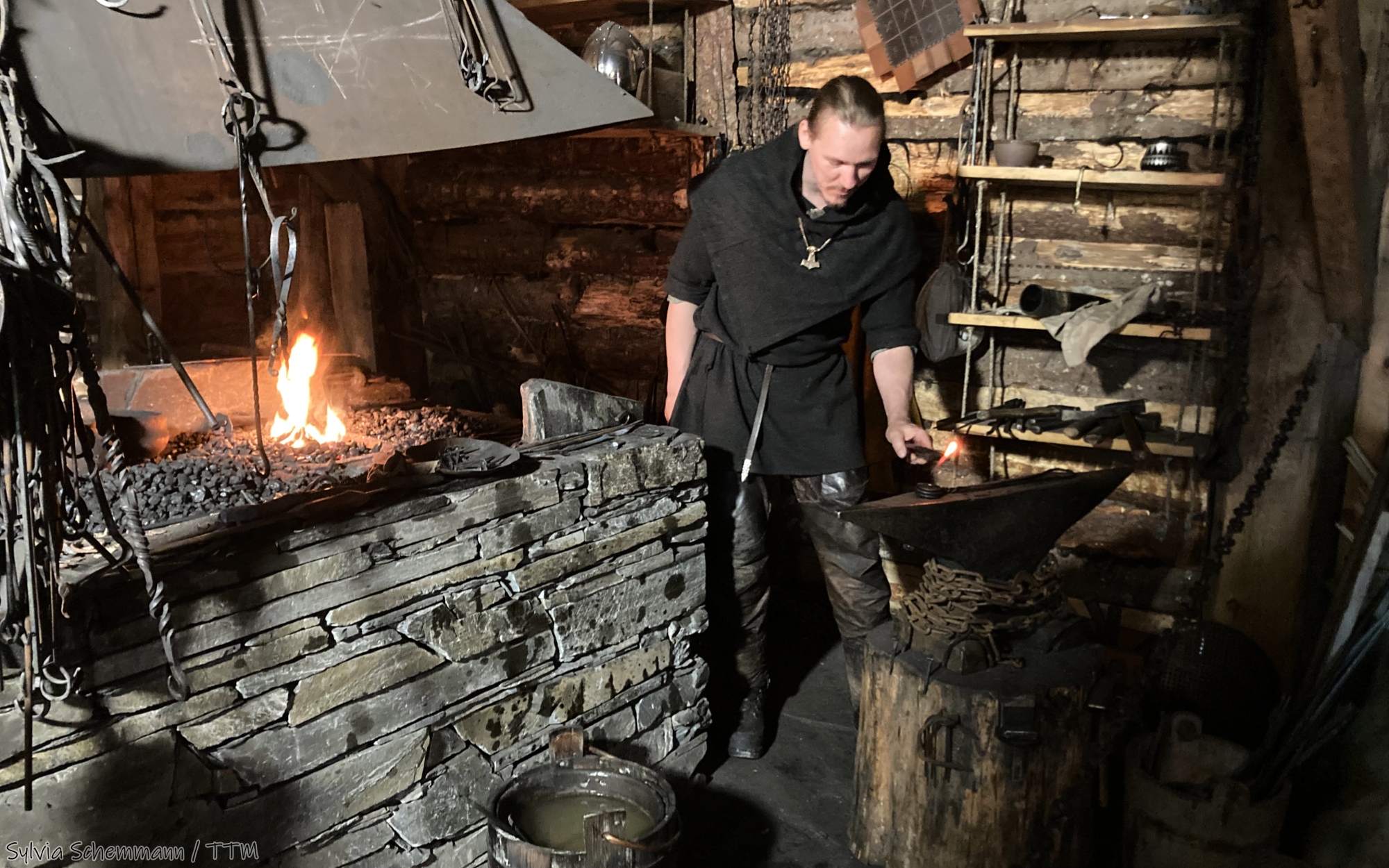 Der Schmied im Wikinger-Dorf Gudvangen, Norwegen, bei der Arbeit in seiner Schmiede.