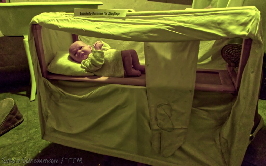 Eine Baby-Puppe liegt in einem Gasschutz-Bettchen für Säuglinge im Bunker-Sanitätsraum.