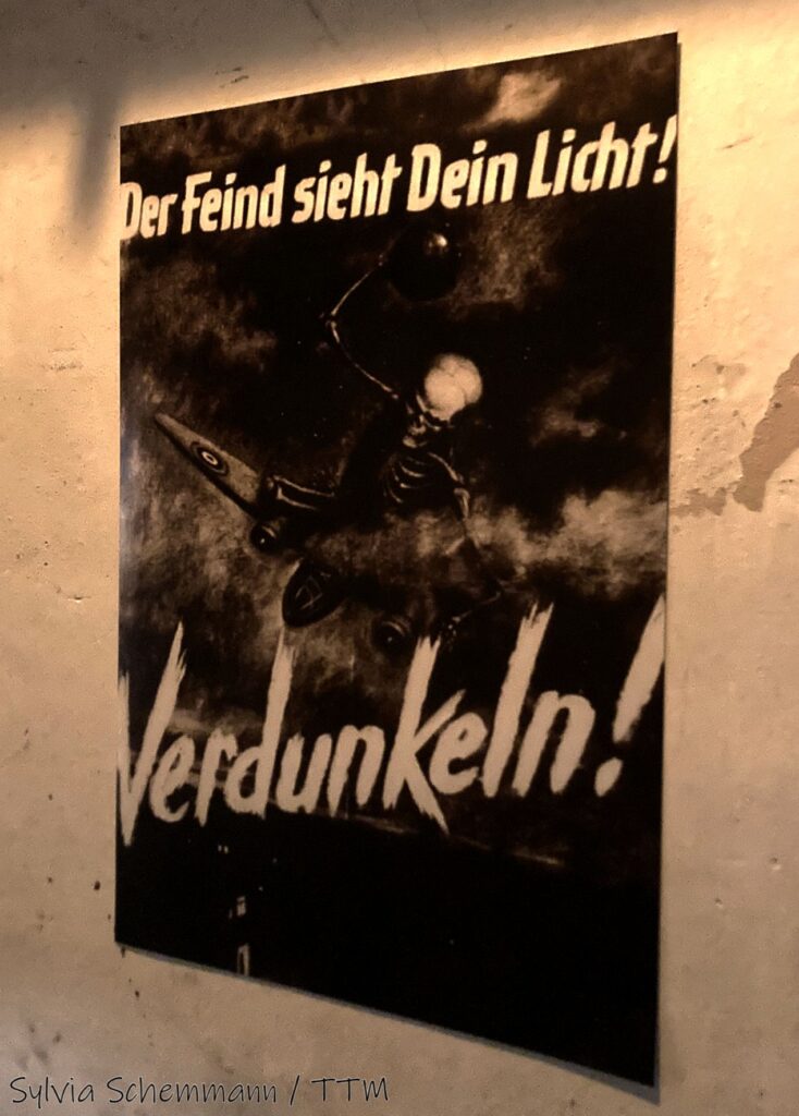 Propaganda-Plakat im Bunker aus der NS-Zeit mit der Aufschrift "Der Feind sieht dein Licht! Verdunkeln!"