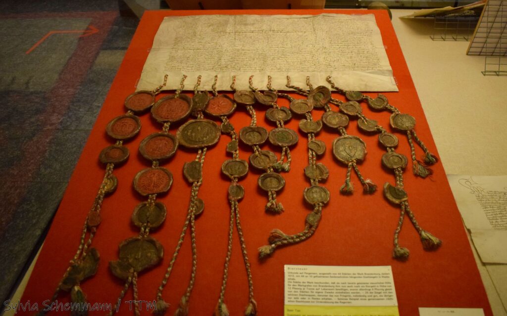 Eine historische Urkunde mit sehr vielen Siegeln daran im Mittelalterlichen Kriminalmuseum Rothenburg.