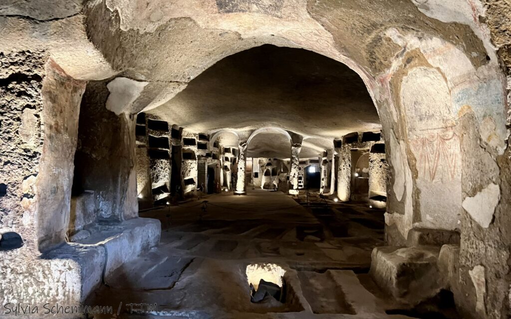 Blick in die Katakombe San Gennaro, Teil der Unterwelten Neapel. Eine Art in den Stein gehauene Kaverne, an beiden Seiten sind Wandnischen zu erkennen, die Grablegen.