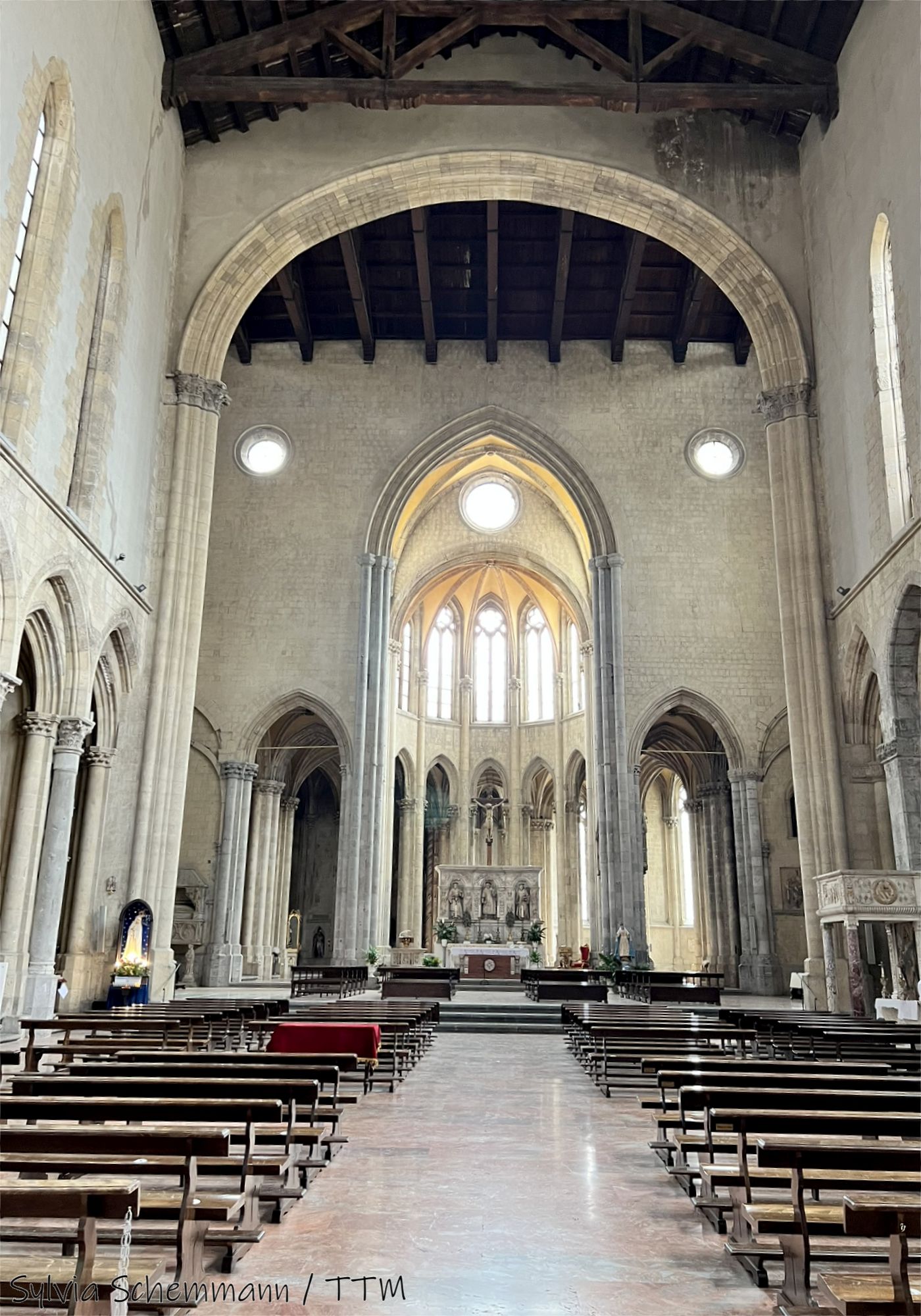 Unterwelten Neapel: Blick in eine hohe, schlichte Kirche mit hellen Wänden und gotischem Stil